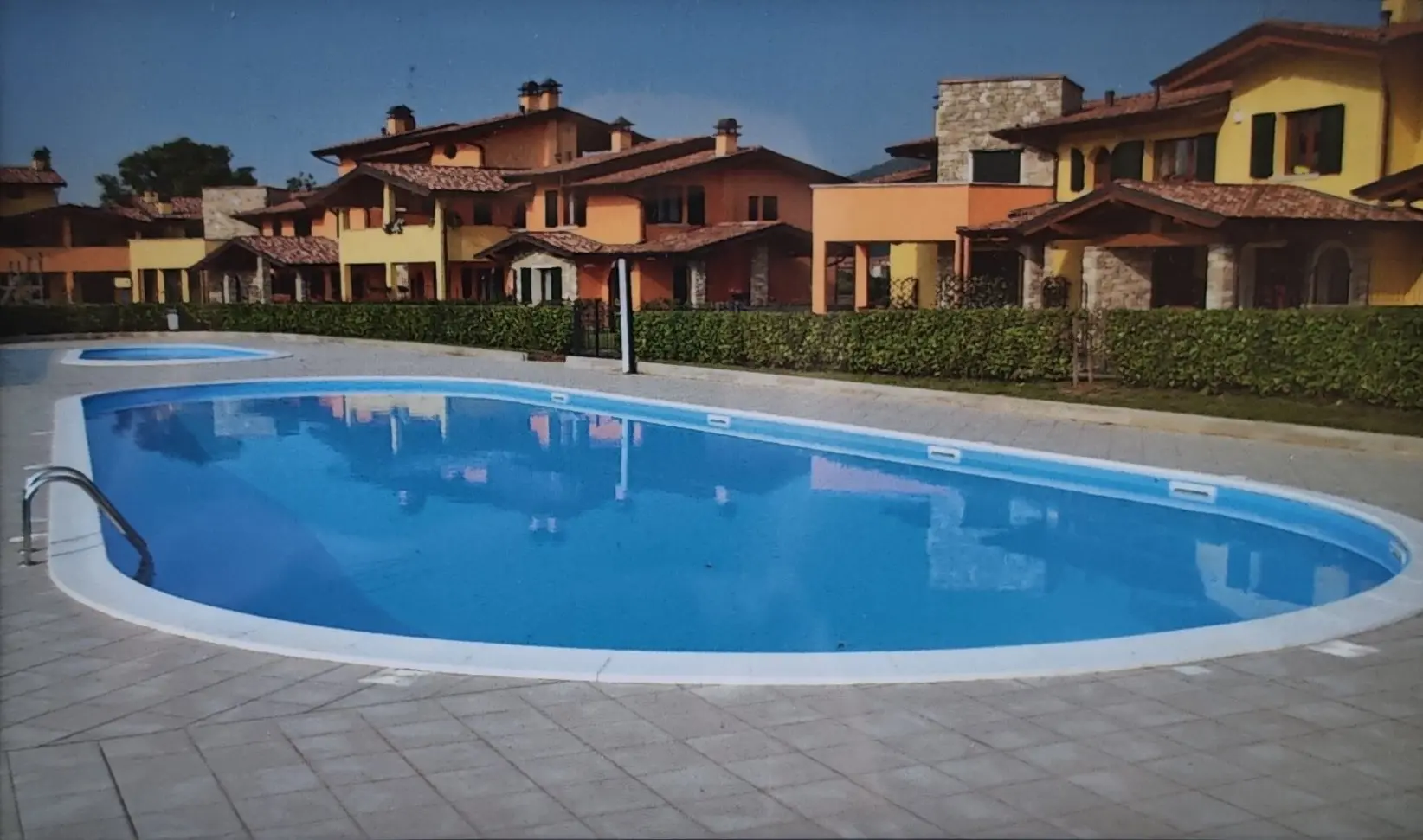 <p>Create a highly detailed and realistic image of a luxurious oval-shaped outdoor pool area that is approximately 500 square feet in size. This pool area is surrounded by modern Mediterranean-style villas in the background, which have soft-colored stucco and terracotta roofing. The pool area needs to be enhanced with elegant wooden decking and high end contemporary lounge furniture. There should also be ambient lighting and lush, vibrant greenery around the perimeter of this pool area, contributing to a vibrant and welcoming environment.</p>